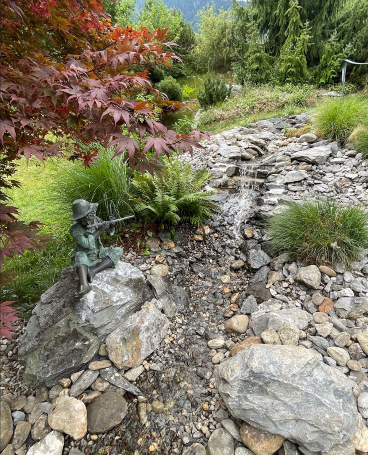 Naturnah gestalteter Wasserfall und Bachlauf nach der Renovierung